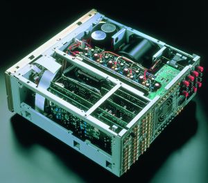 Lift the lid and we see the 5-channel output stage (centre) straddled by the power supply (top) and DSP processing (bottom of pic). Note the fan cooling duct at the centre of the rear panel.